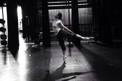 Full length of ballerina practicing in studio