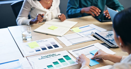 Midsection of business colleagues working on table