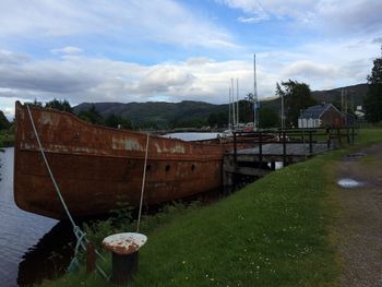 Boats moored on river against sky