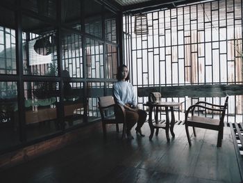 Portrait of woman sitting on chair at cafe