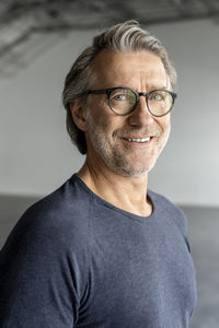 Smiling businessman with eyeglasses at industial hall