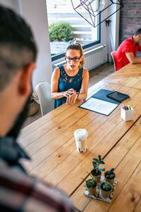 Angry female manager discussing with man for coming late to office