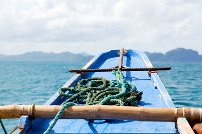 Close-up of rope tied on bollard against sky