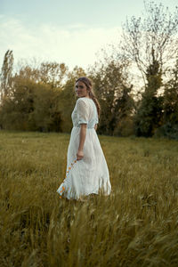 Woman standing on field against sky