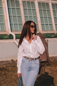 Full length of woman standing against wall