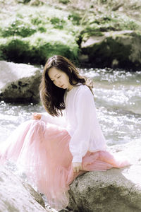 Young woman sitting on rock