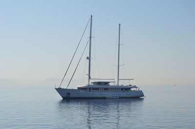 Sailboat sailing on sea against clear sky