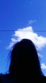 Low angle view of woman against blue sky