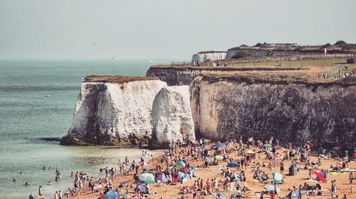 People at beach against clear sky