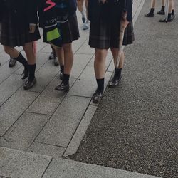 Low section of women walking on zebra crossing