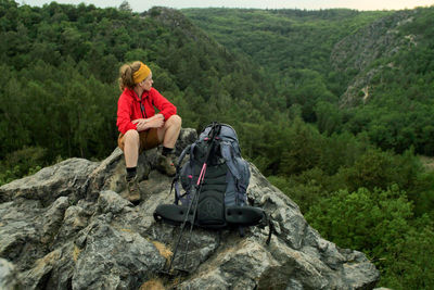 Hiker sitting on rocky mountain