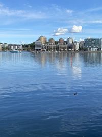 View of lake and buildings against sky