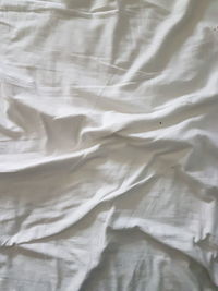 Full frame shot of crumpled white sheet on bed