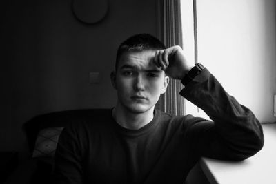 Portrait of young man sitting at home