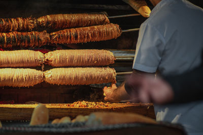 Man working on barbecue grill ccoking sheep's intestines at market