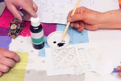 High angle view of people playing with paper on table