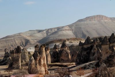 Fairy chimneys by mountain at cappadocia