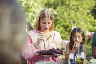Girls eating lunch in back yard during garden party