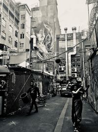 People on street amidst buildings in city