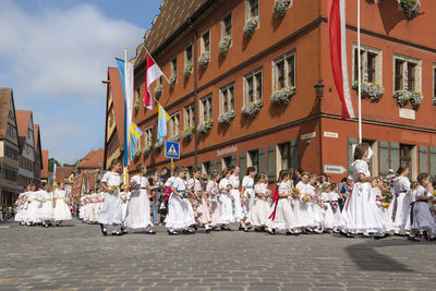 People on street against buildings in city