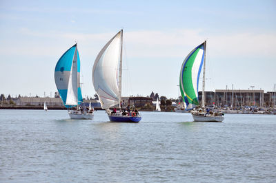 Sailboats in sea against sky