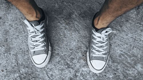 Low section of man standing on tiled floor