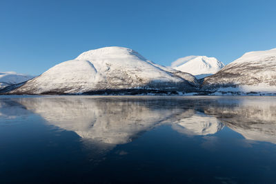 Scenic view of frozen lake against clear blue sky