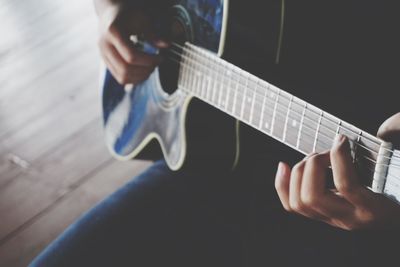 Midsection of man playing guitar