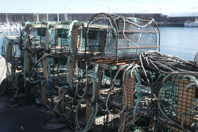 Pile of lobster pots in a fishing port against sea