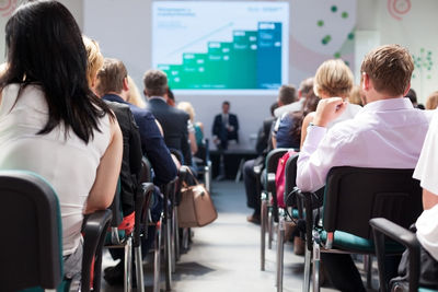 Rear view of people sitting in conference