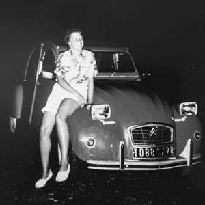 Portrait of woman standing against car at night
