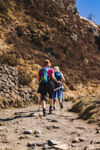 Rear view of women walking on mountain road