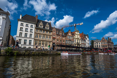 River by buildings against sky