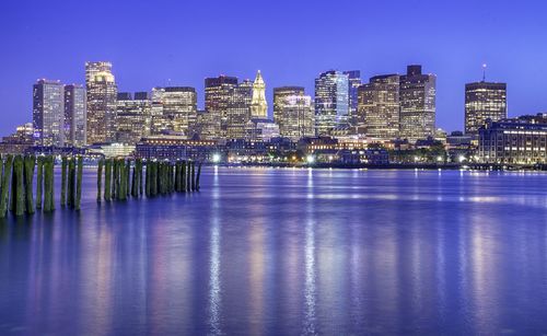 Illuminated buildings in city against clear sky