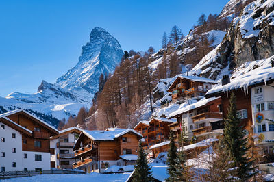 Snow covered houses and buildings against sky