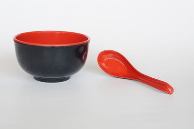 Close-up of red tea cup against white background