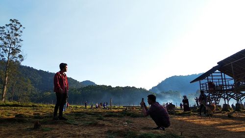 Man photographing friend standing on land