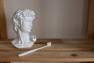 The plaster head stands next to the toothbrush.