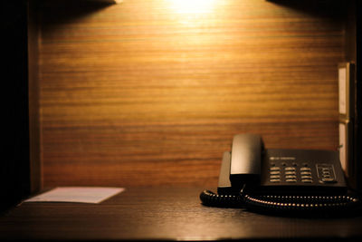 Close-up of telephone on table against wall
