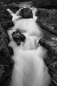 Black and white scenic view of waterfall. 