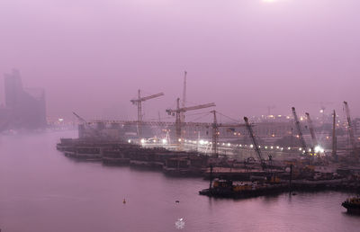 Boats moored at harbor against sky at night