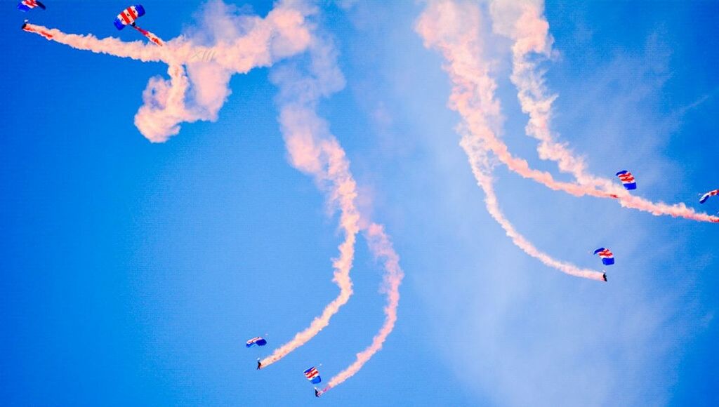 flying, low angle view, mid-air, parachute, extreme sports, fun, leisure activity, kite - toy, adventure, blue, paragliding, exhilaration, enjoyment, kite, freedom, sky, motion, sport, airshow