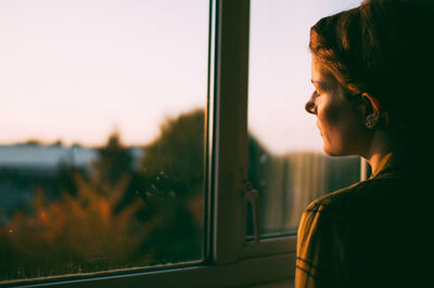 Portrait of woman looking through window