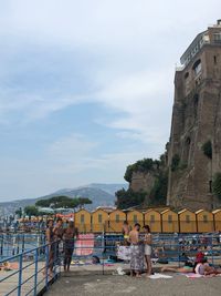 People on historic building against sky