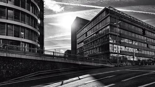 Road by buildings in city against sky