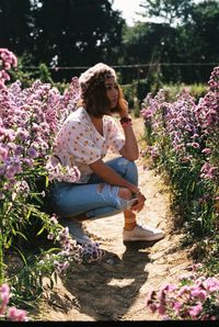 Woman sitting on purple flowering plants