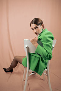 Side view of woman sitting on chair