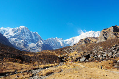 Scenic view of snowcapped mountains against blue sky