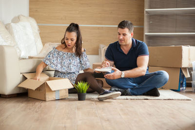 Friends using digital tablet while sitting at home