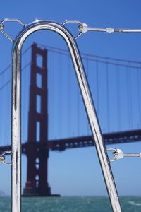 Close-up of boat railing with golden gate bridge in background